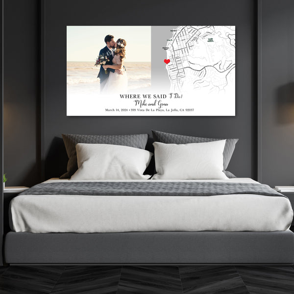 A "Where We Said I Do" canvas hanging on a wall over a grey and white bed.