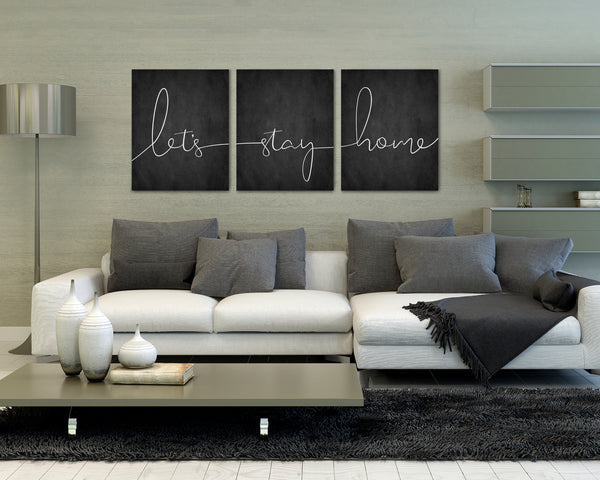 “Let’s Stay Home 3-piece canvas wall art set hanging above a couch in a modern living room”