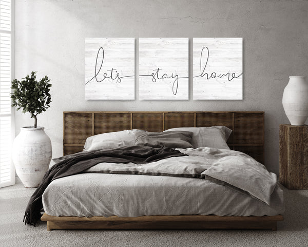 “Let’s Stay Home 3-piece canvas wall art set hanging above bed.