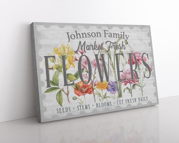 Close up of a custom flower market canvas showing detailed spring flower illustrations on a white wood background. 