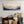 Living room with a wooden bench, pillows, and a large abstract painting on the wall.