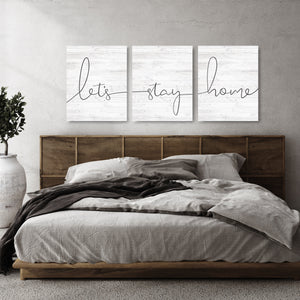 “Let’s Stay Home 3-piece canvas wall art set hanging above bed.
